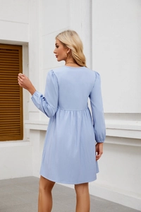 Dettaglio del retro di un abito babydoll azzurro a maniche lunghe con texture a pieghe