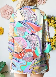 Detail of tropical leaf print pattern on long sleeve shirt from a back view perspective