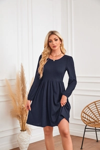 Détail de la robe en maille bleu marine montrant la texture gaufrée et la taille haute