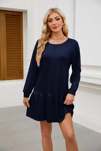 Detail of navy blue long sleeve dress with ruffle hem and crew neck on a female model