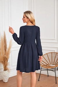 Texture détaillée d'une robe trapèze en tricot bleu marine avec col rond et plis