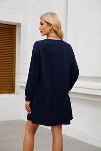 Close-up of navy blue long sleeve dress featuring a stylish ruffled hemline and loose fit