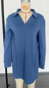 Détail d'une robe polo bleu-gris à manches longues avec col classique et col en V