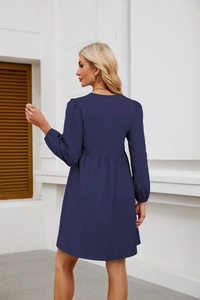 Dettaglio dell'abito babydoll blu navy a maniche lunghe con pieghe in vita e texture