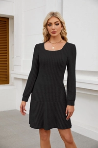 Detailed texture of black square-neck lantern sleeve knitted dress on model outdoors