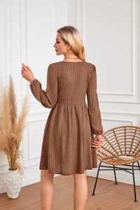 Détail d'une robe marron à manches longues avec texture en maille côtelée et jupe évasée