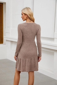 Detail of brown ribbed knit texture and pleated hem of the long sleeve sweater dress