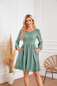 Détail de la robe tricotée vert herbe montrant le tissu texturé et la poche latérale