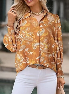 Detail of ginger paisley print shirt featuring button-down front and elastic lantern sleeves