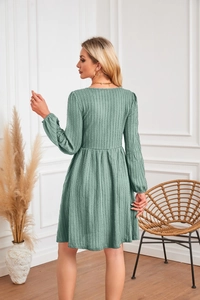 Détail de la robe trapèze vert sauge en maille texturée avec une taille empire élégante
