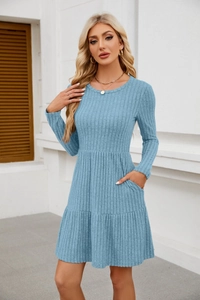 Detailed texture of light blue knit sweater dress with side pockets and pleated hemline