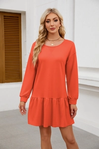 Detail of coral crewneck sweatshirt dress featuring a cross-stitch neckline and ruffled hem