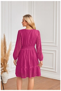 Dettaglio dell'abito in pizzo rosso rosa con ricami e orlo a balze per uno stile chic