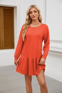 Close-up of bright orange crewneck long sleeve dress with elegant ruffle hem detail