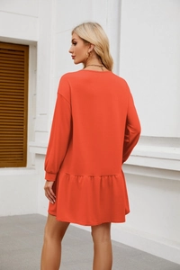 Detail of orange long sleeve sweatshirt dress with elegant ruffled hemline and loose A-line cut