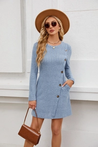 Dettaglio dell'abito in maglia azzurro con costine verticali e bottoni decorativi laterali