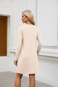 Detail view showing the back vertical seam and A-line cut of this beige knit mini dress