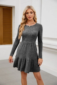 Detail showing the ribbed knit texture and ruffled hem of a long sleeve grey dress