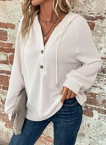 Close-up of waffle knit texture and button V-neck detail on white long sleeve hoodie