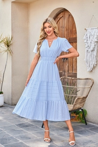 Macro detail of light blue tiered dress featuring V-neckline and textured striped fabric