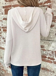 Detail of waffle knit fabric texture on the back of a cream long sleeve hoodie