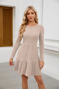 Detail view of beige ribbed knit sweater dress featuring ruffle hem and long sleeves