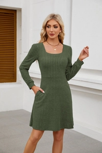 Détail d'une robe en maille vert foncé avec encolure carrée et poches latérales
