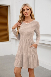 Detail of apricot ribbed knit dress featuring practical side pockets and tiered skirt