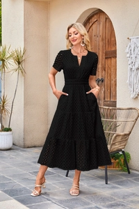 Dettaglio ricamo eyelet con scollo a V e vita plissettata su abito midi nero corto