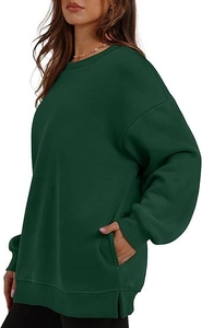 Detail view of oversized dark green sweatshirt featuring side slits and hidden pockets