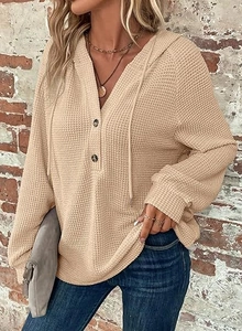 Detail of waffle knit fabric and button-up V-neck on the beige long sleeve hoodie