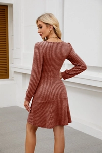 Detailed texture of dark red ribbed knit dress with slim waist and ruffled hem