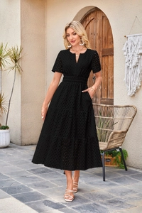 Dettaglio dell'abito nero con ricamo eyelet, scollo a V, tasche e gonna a balze elegante