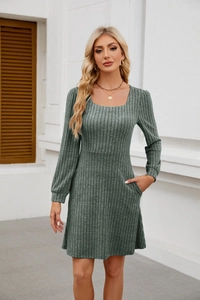 Détails du col carré et des manches bouffantes sur une robe en maille vert foncé