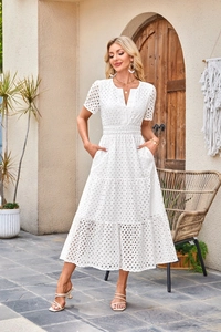 Dettaglio dell'abito midi bianco con scollo a V, ricamo a occhielli e gonna a balze
