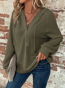 Detail of army green waffle knit texture and V-neckline with decorative buttons and drawstring
