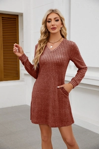 Detail eines gerippten Strickkleides mit V-Ausschnitt in Rostrot und Taschen