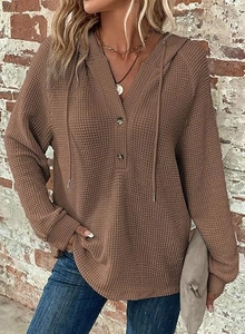 Detail of waffle knit fabric on brown hoodie with buttoned V-neck and drawstring