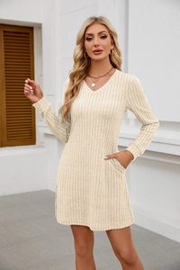Detailansicht des cremefarbenen Strickkleides mit V-Ausschnitt, Rippstruktur und Taschen