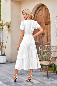 Detail of white midi dress featuring V-neck, puffed sleeves and layered ruffle hem cake skirt