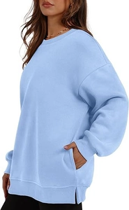 Side view of light blue oversized sweatshirt featuring side slits and functional pockets