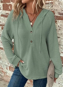 Detailed close-up of sage green waffle knit texture and buttoned V-neck with drawstrings