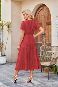 Detail view of the red tiered midi dress showing short sleeves and elastic waist smocking