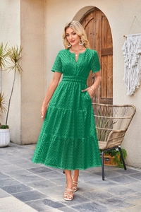 Dettaglio dell'abito midi verde smeraldo con scollo a V, ricamo traforato e gonna a balze