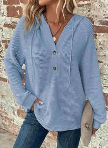 Detailed shot of light blue waffle knit hoodie with wood buttons and drawstring V-neckline