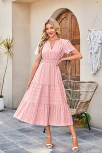 Detailed close-up of pink tiered dress with V-neck, elastic waist and texture fabric