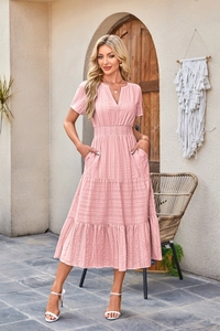 Detail of pink V-neck tiered dress featuring smocked waist and puffed short sleeves