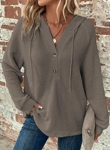 Detail of waffle knit fabric texture on a taupe V-neck drawstring hoodie for women
