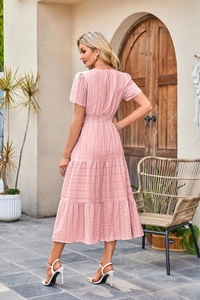 Close-up of pink V-neck dress featuring elastic ruched waist and tiered cake skirt layers