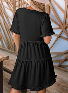 Rear view of tiered black mini dress with ruffle trim and soft summer fabric details